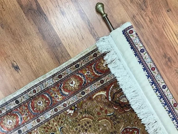 A silk rug with a hand-woven sleeve for hanging it on the wall.