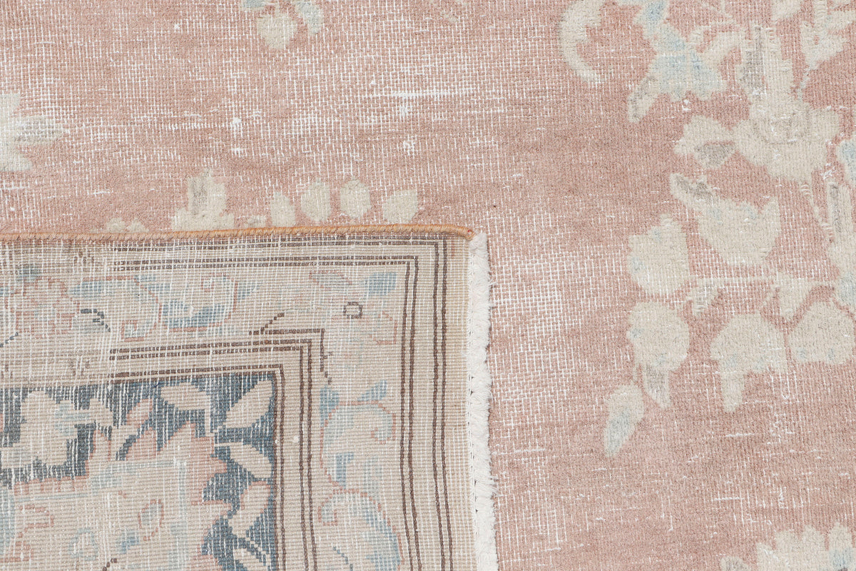 A hand-knotted 10x13 vintage wool rug featuring a blush colour combination.