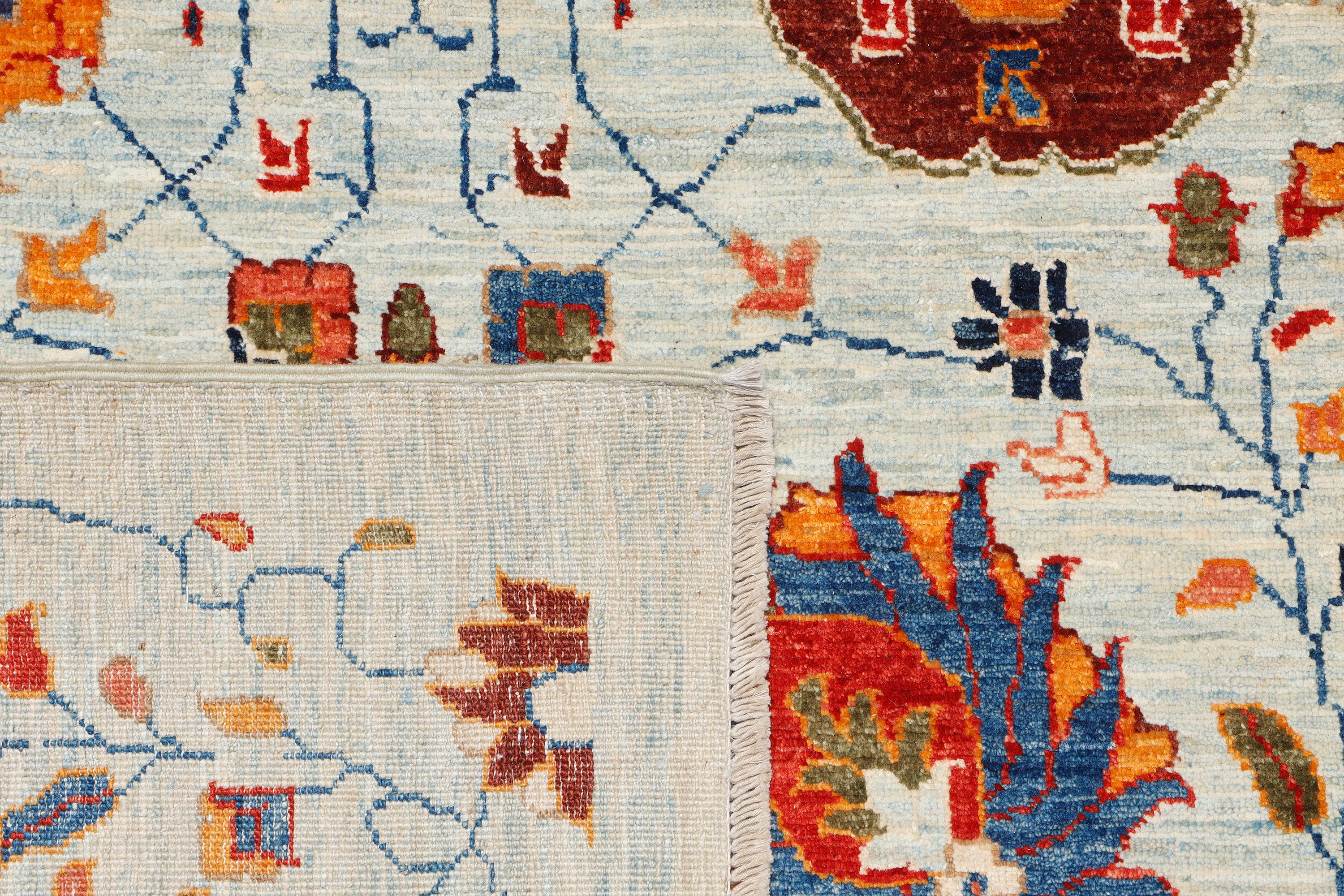 A handmade 10x12 wool rug featuring an all-over floral pattern.