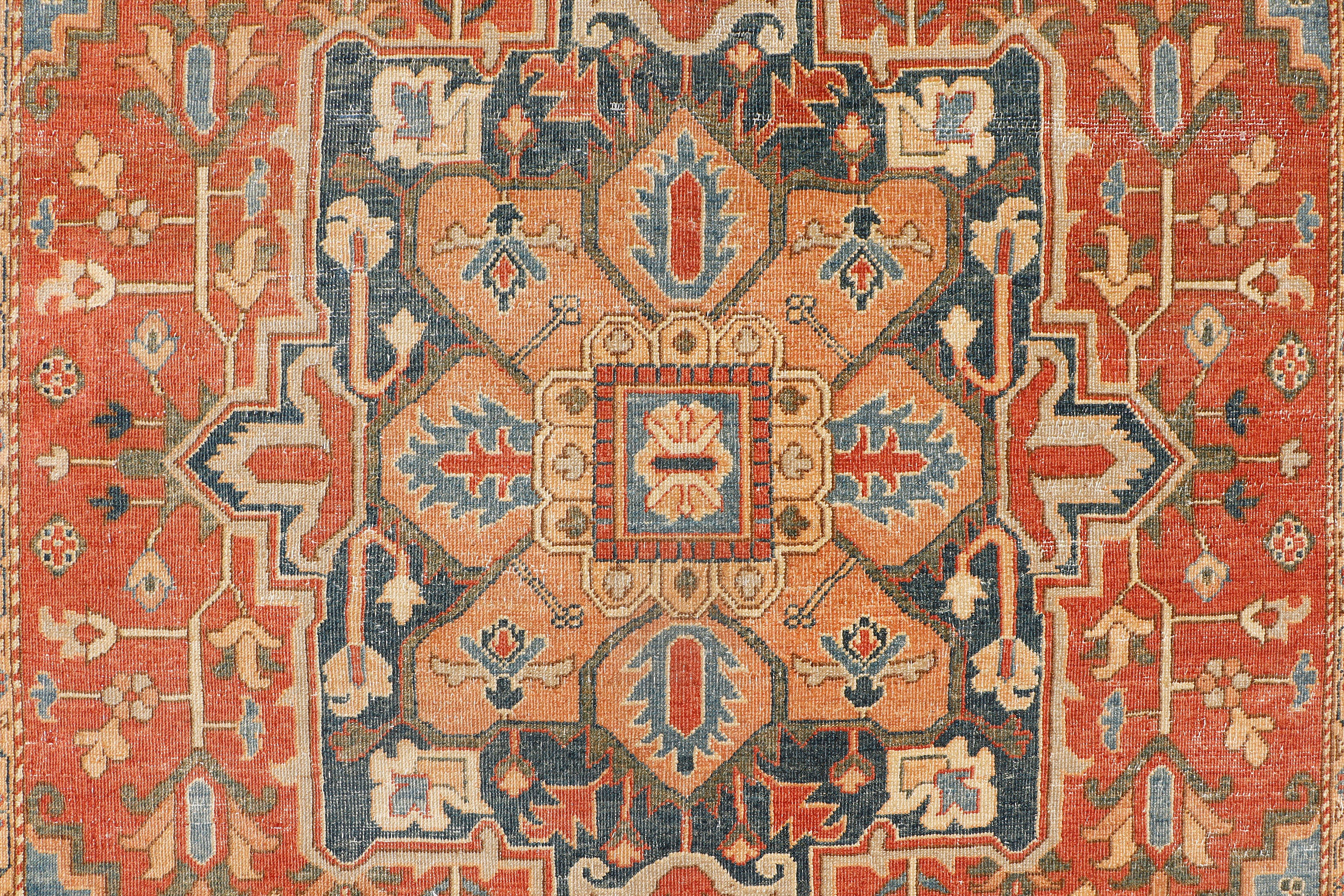 A hand-knotted antique-style wool rug featuring a classic Serapi design.