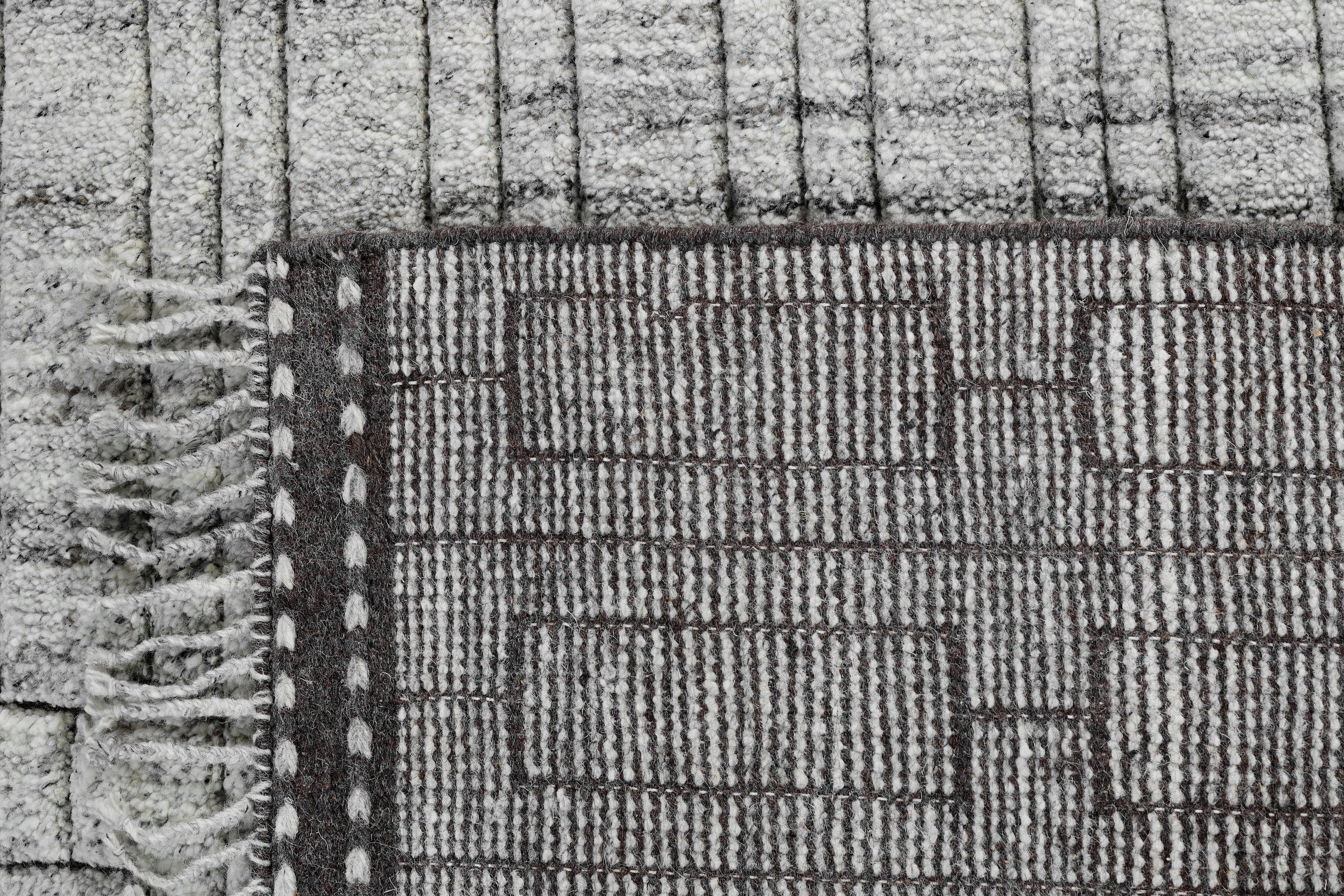 A hand-knotted modern wool rug in a neutral grey colour combination.