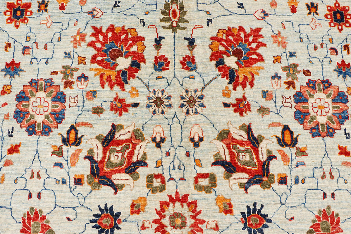 A handmade 10x12 wool rug featuring an all-over floral pattern.