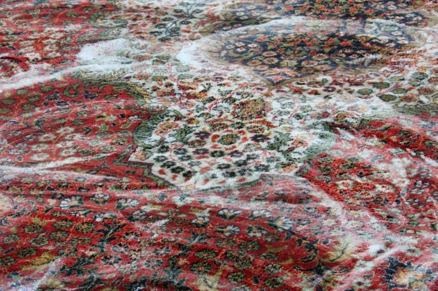 A close-up of a handmade area rug being professionally cleaned in Toronto.